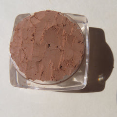 Close-up of matte brown loose mineral eyeshadow powder with vegan pigments in eco-friendly packaging