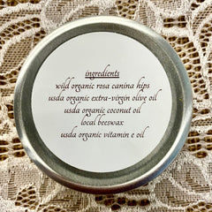 Ingredients label with silver rim, white background, and dark brown text on lace fabric