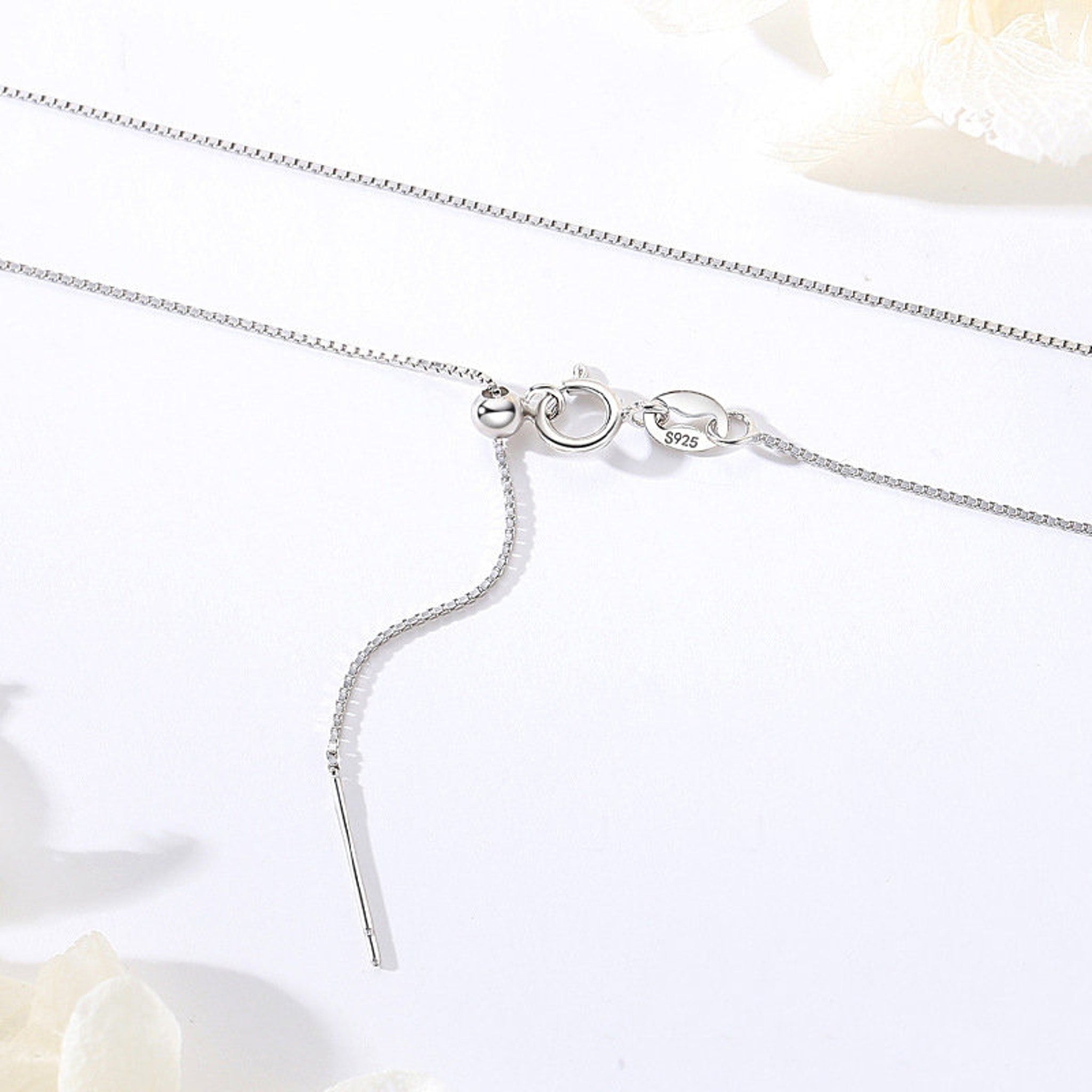 Close-up of sterling silver chain necklace showcasing textured silver and gold links with secure clasp