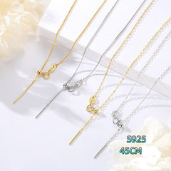 Close-up of sterling silver chain necklace with alternating silver and gold links on a flat surface