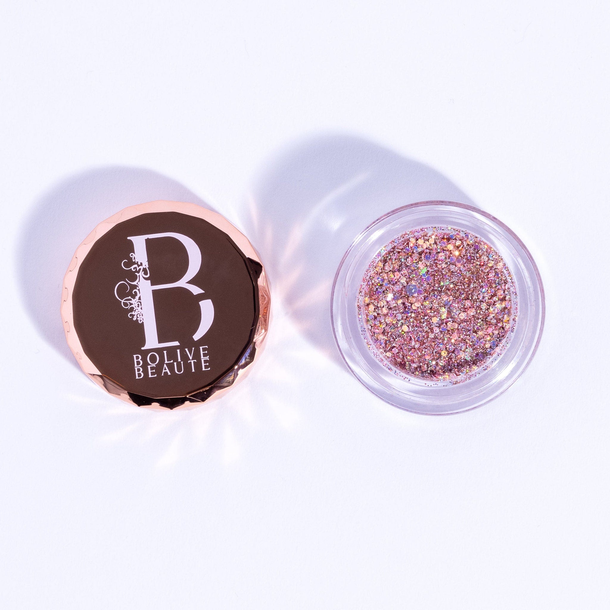 Close-up of rose gold glitter eyeshadow palette with shimmer particles in compact case