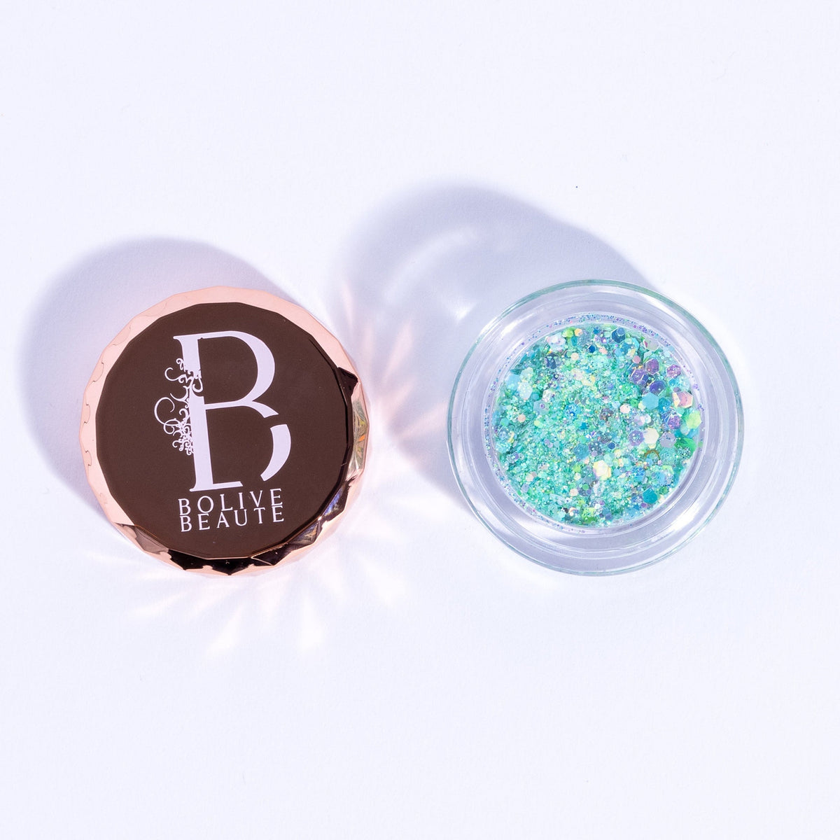 Close-up of mint green glitter eyeshadow in Mojito shade with sparkling shimmer particles in compact case
