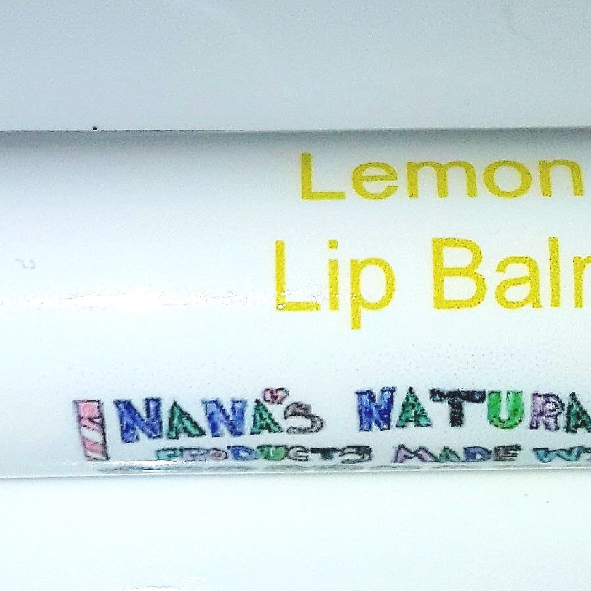 Lip balm with yellow text, white background, and Nana's Naturals branding.