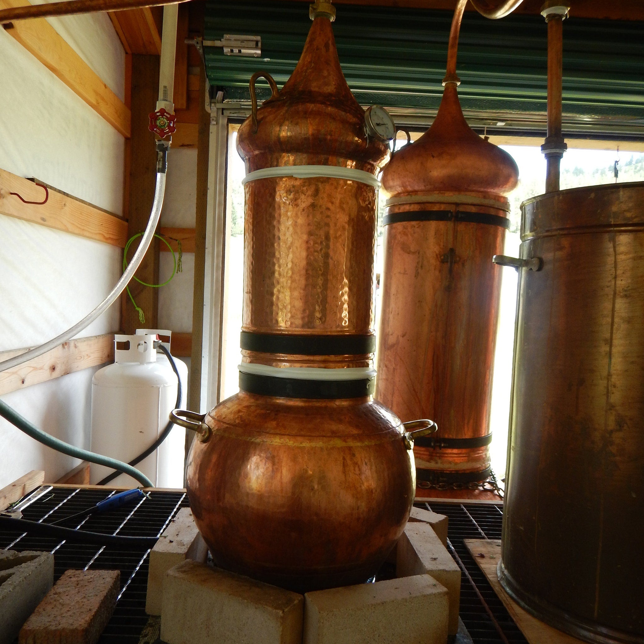Copper still with copper and black bands, used for distilling liquids