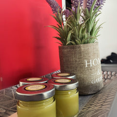 Yellow jars with silver lids, on a decorative tray with a burlap plant pot and faux lavender