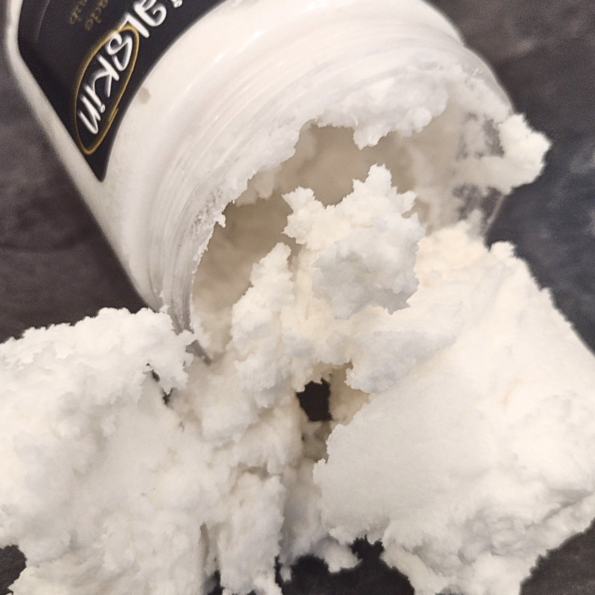 Creamy white product with visible texture, spilled from jar, brand label visible on container