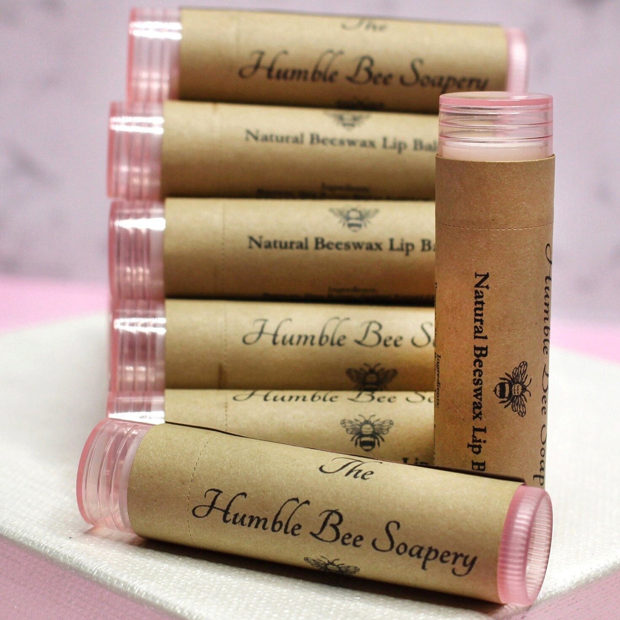 Lip balm tubes with pink caps and brown paper labels, "The Humble Bee Soapery" printed