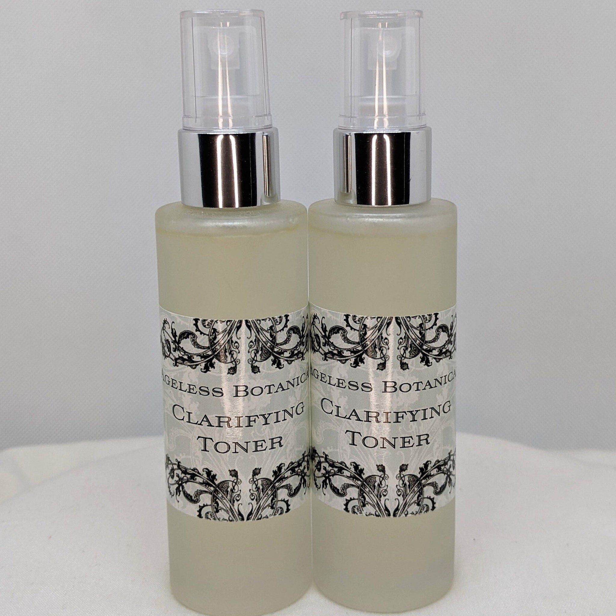 Clarifying toner bottles with clear spray tops, frosted glass, and Ageless Botanica label