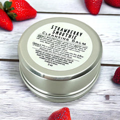 Cleansing balm tin, silver metal container with white label, "Strawberry Smoothie" text visible