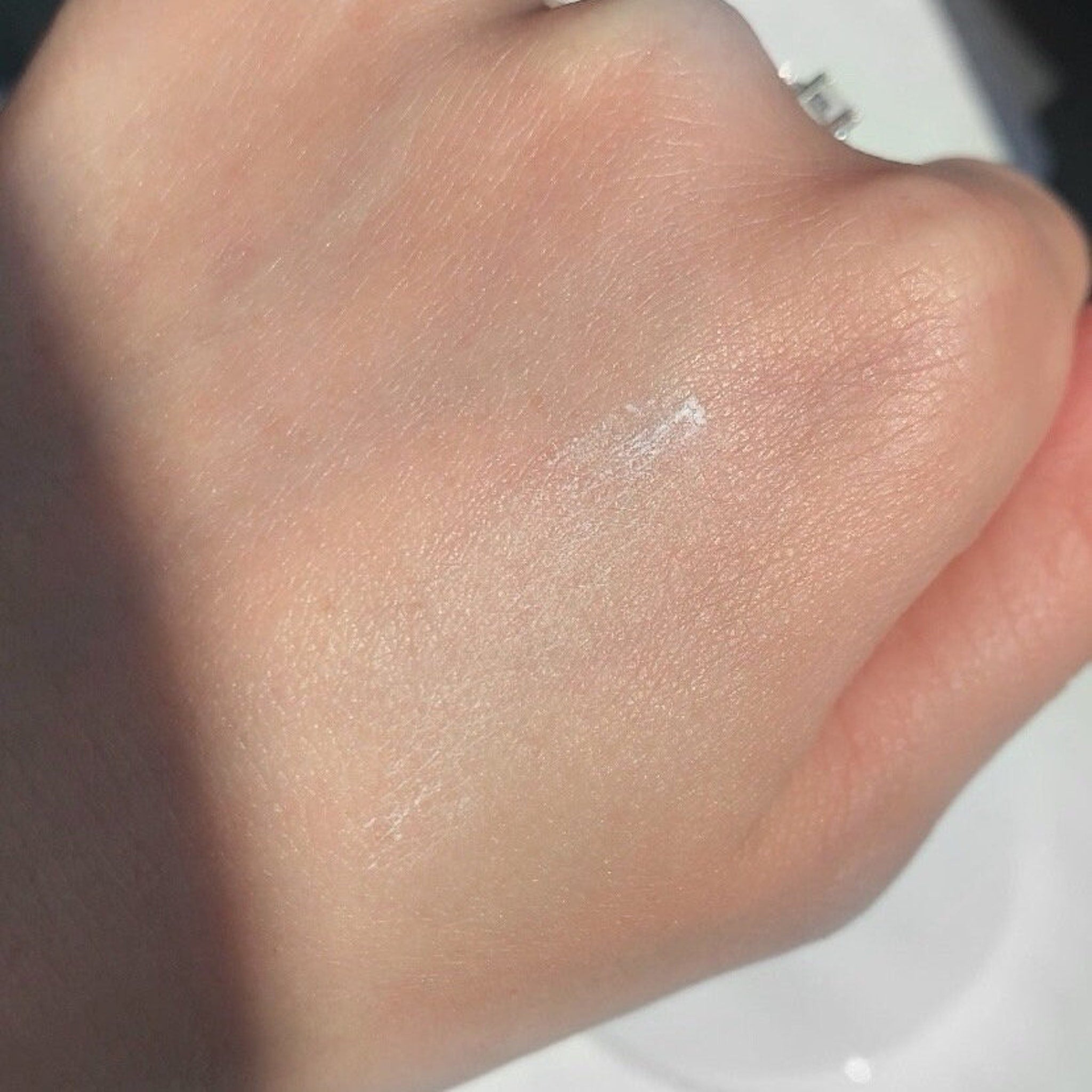 Hand skin with light pink tone, visible texture, and small white powder application