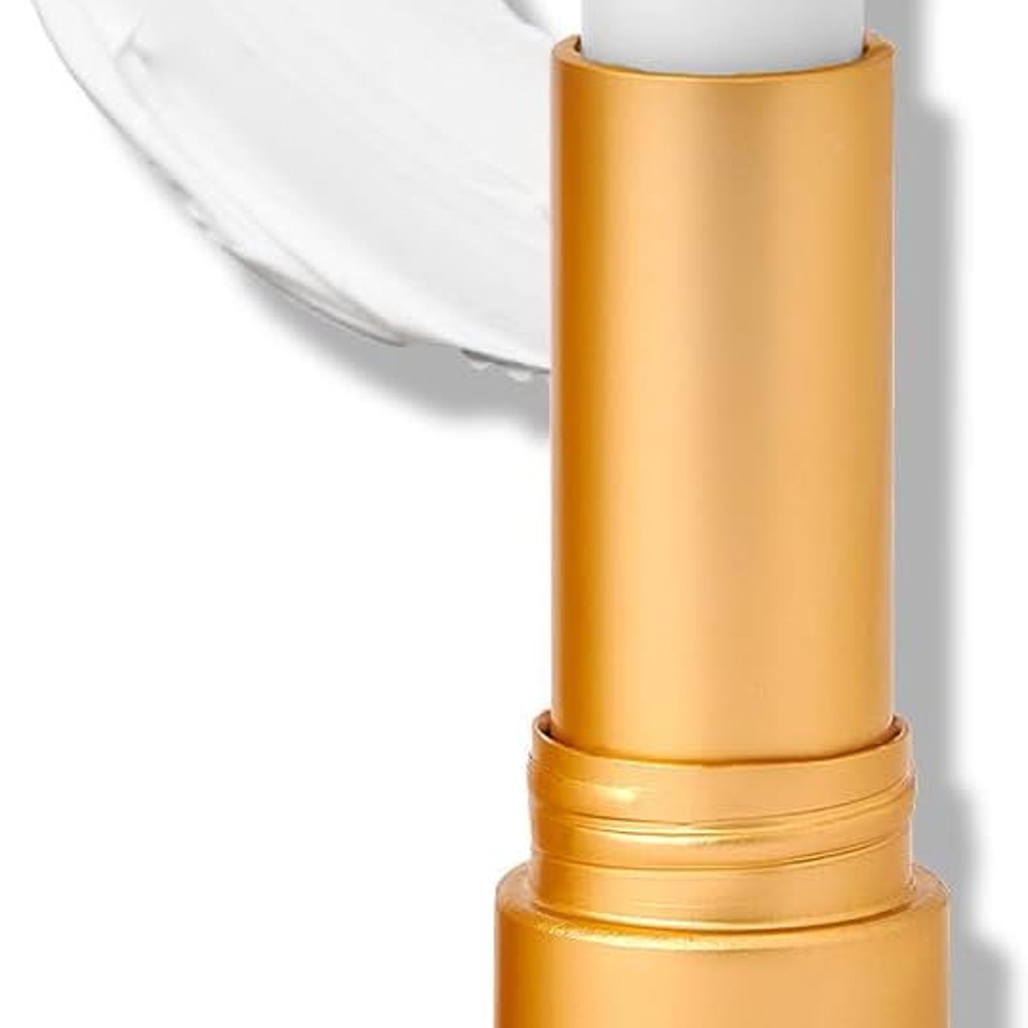 Lip balm tube with gold metallic finish and white product application, close-up view