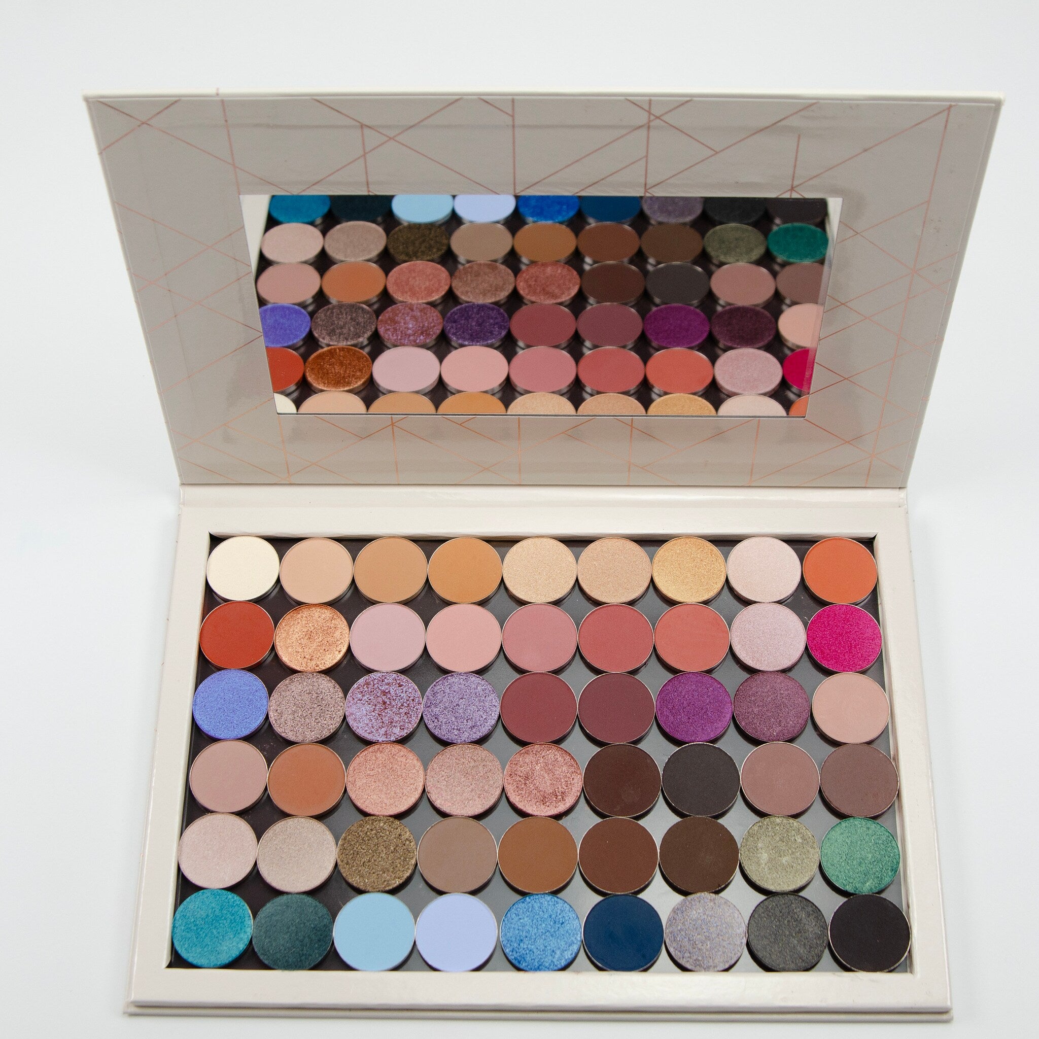Close-up of pressed pigments in 54-pan palette showing shimmer textures and vibrant color payoff