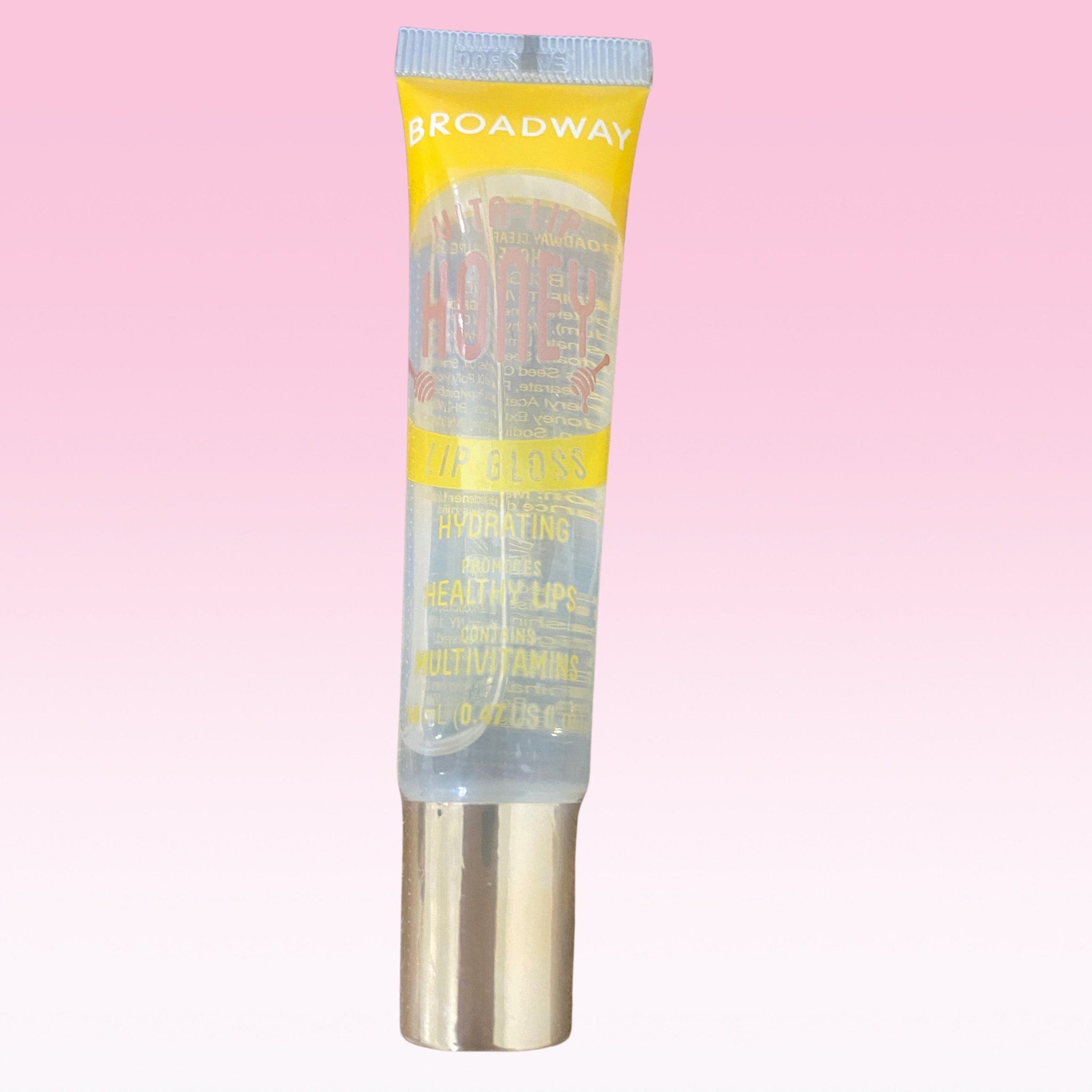 Lip gloss tube with yellow and clear packaging, Broadway Vita Soft brand, gold base