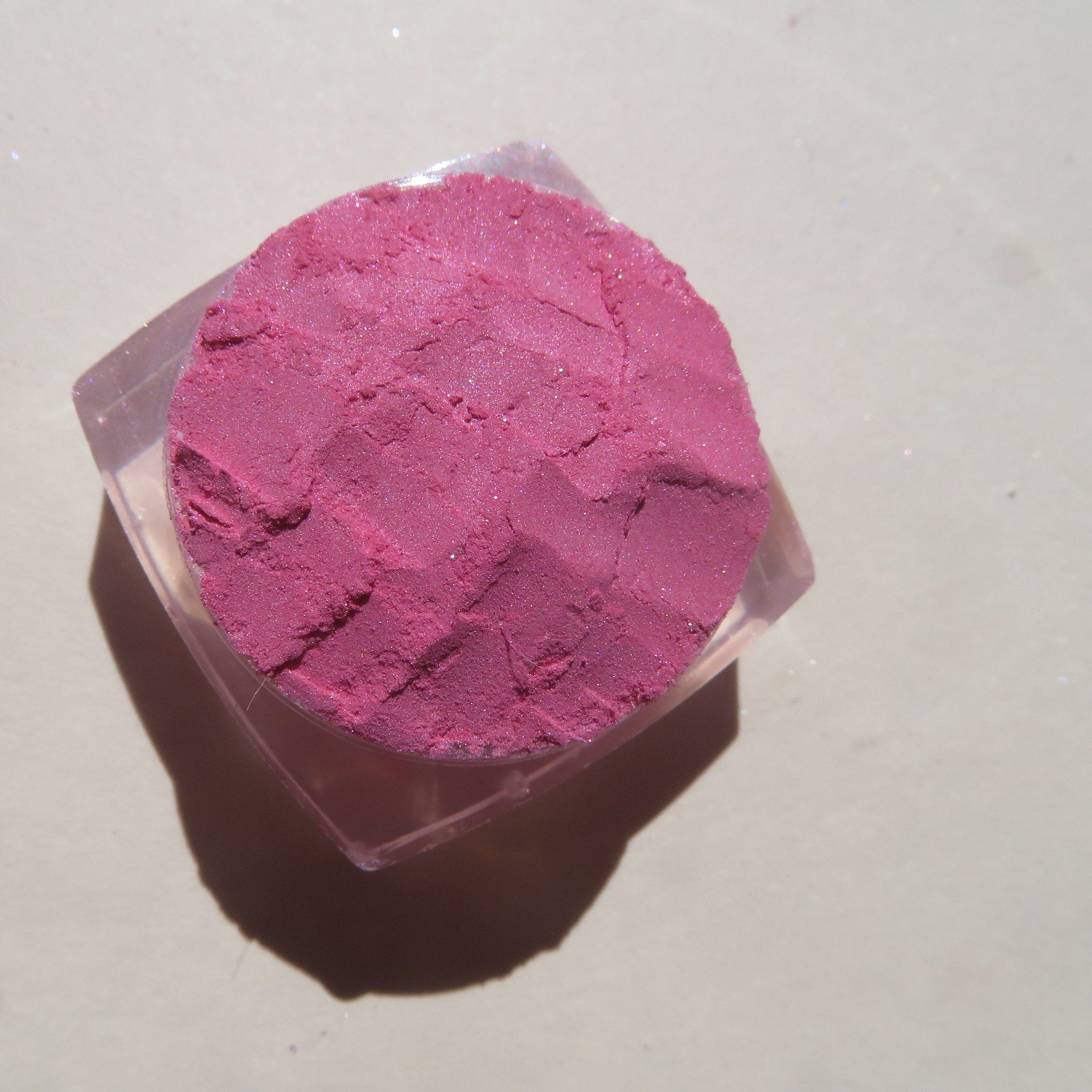 Close-up of loose bubblegum pink mineral eyeshadow powder with soft sheer finish, vegan and cruelty-free