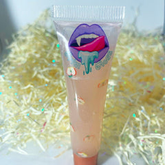 Lip gloss tube with clear, pink liquid, apple pattern, and "Grim Gloss" text design