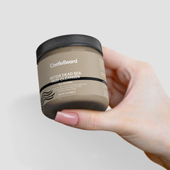 Mud cleanser jar, tan container with black lid, held by hand with pink nails