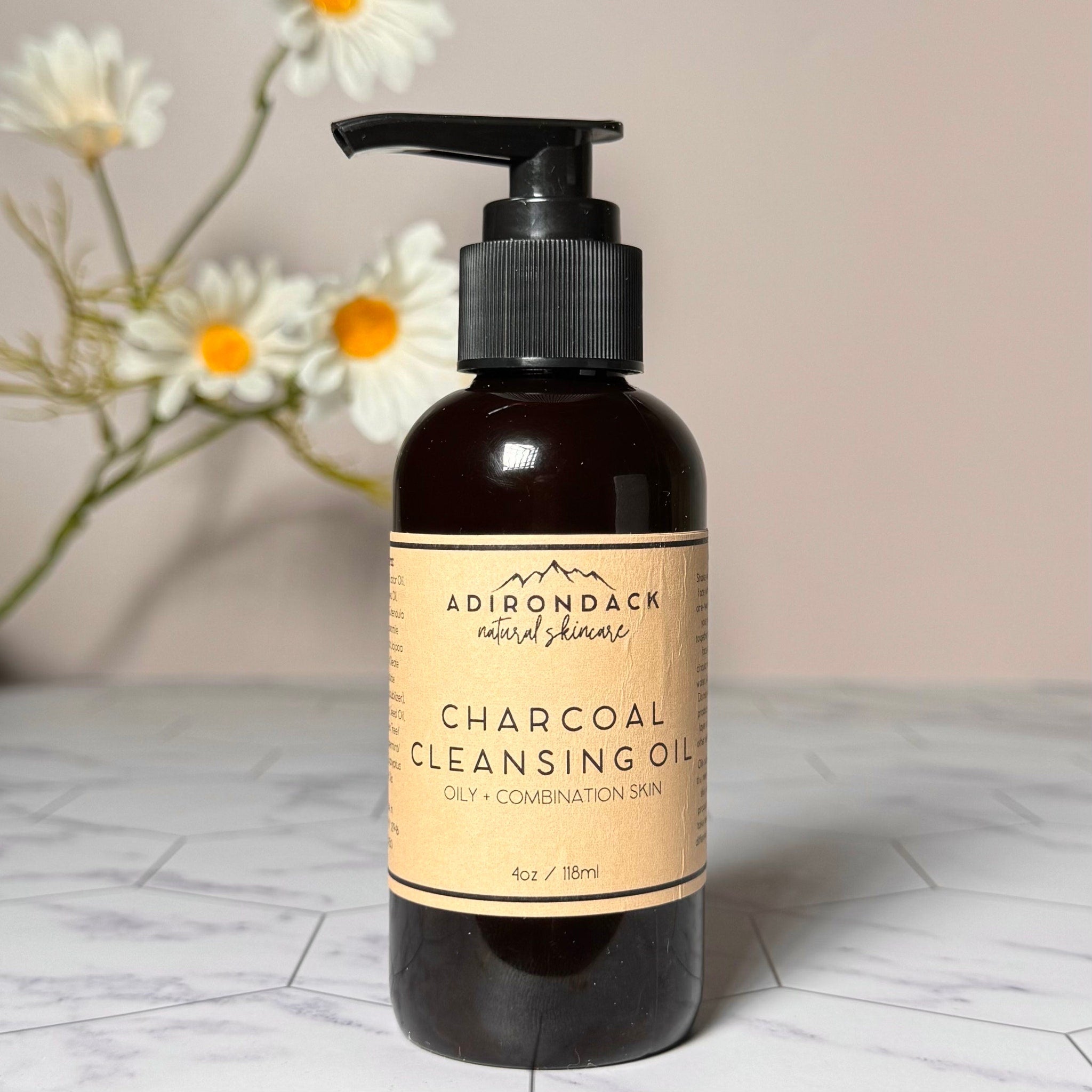 Charcoal cleansing oil bottle, dark brown glass, black pump, with Adirondack Natural Skincare label