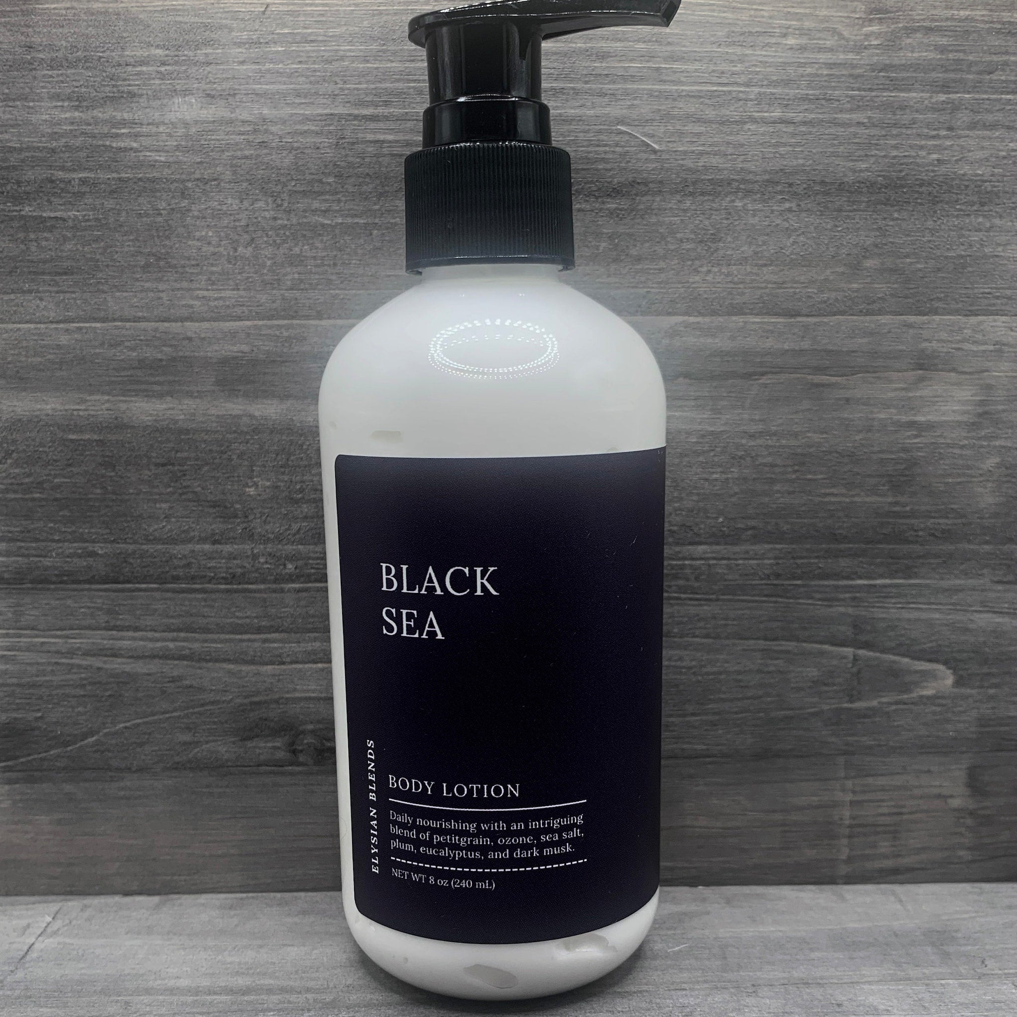 Body lotion bottle with white and black label, black pump, and brand name Black Sea