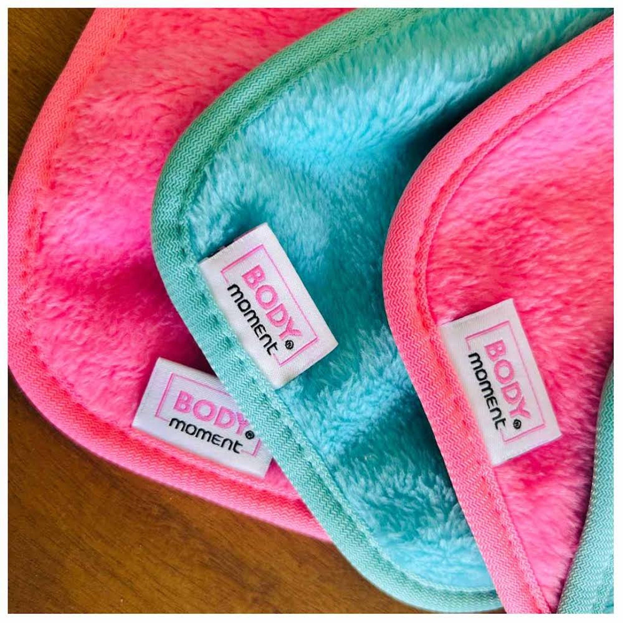 Reusable makeup remover pads in pink, blue, and green with textured trim and Body Moment tag