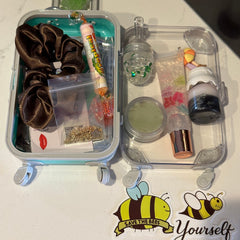Scrunchie and lip gloss set with brown scrunchie, clear container, and stickers on white surface