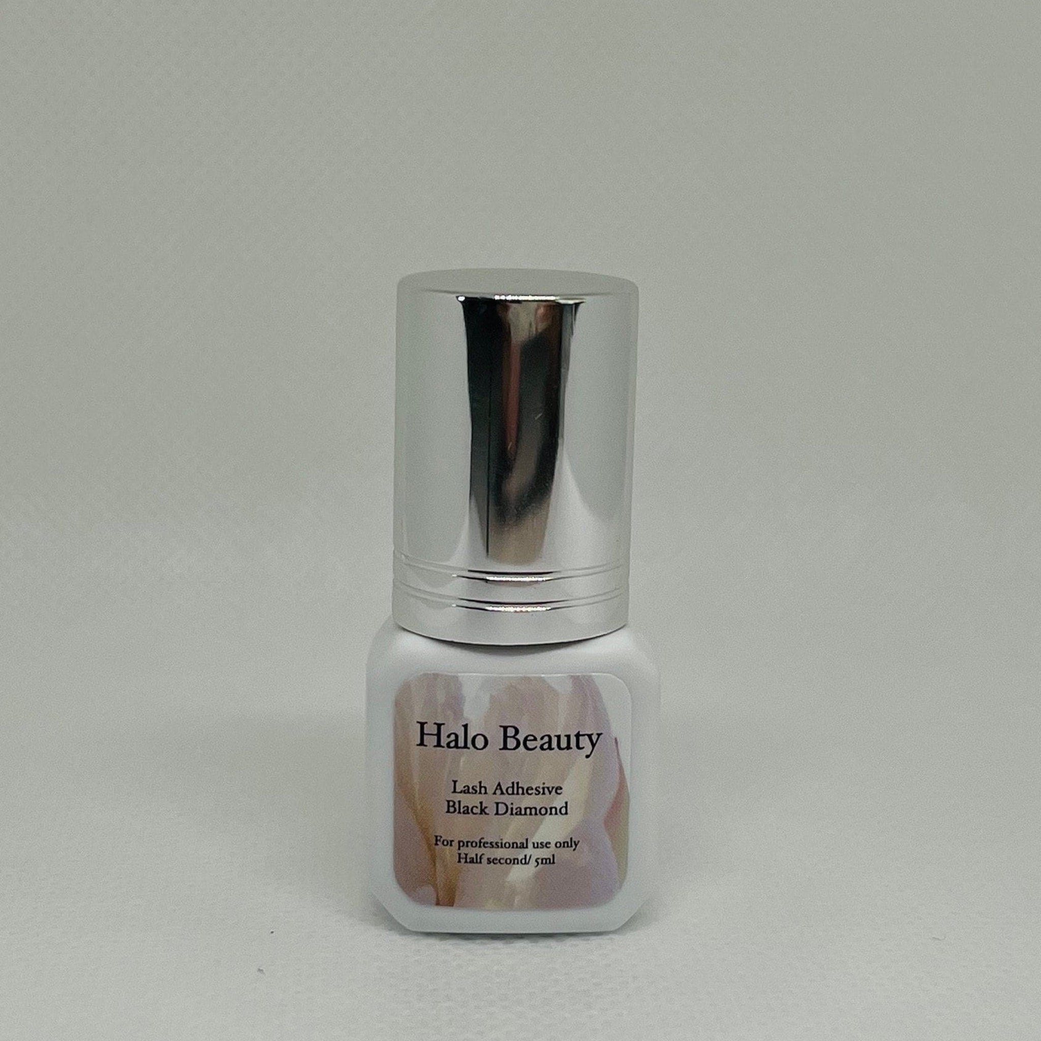Lash adhesive bottle with silver cap, white label, and Halo Beauty text