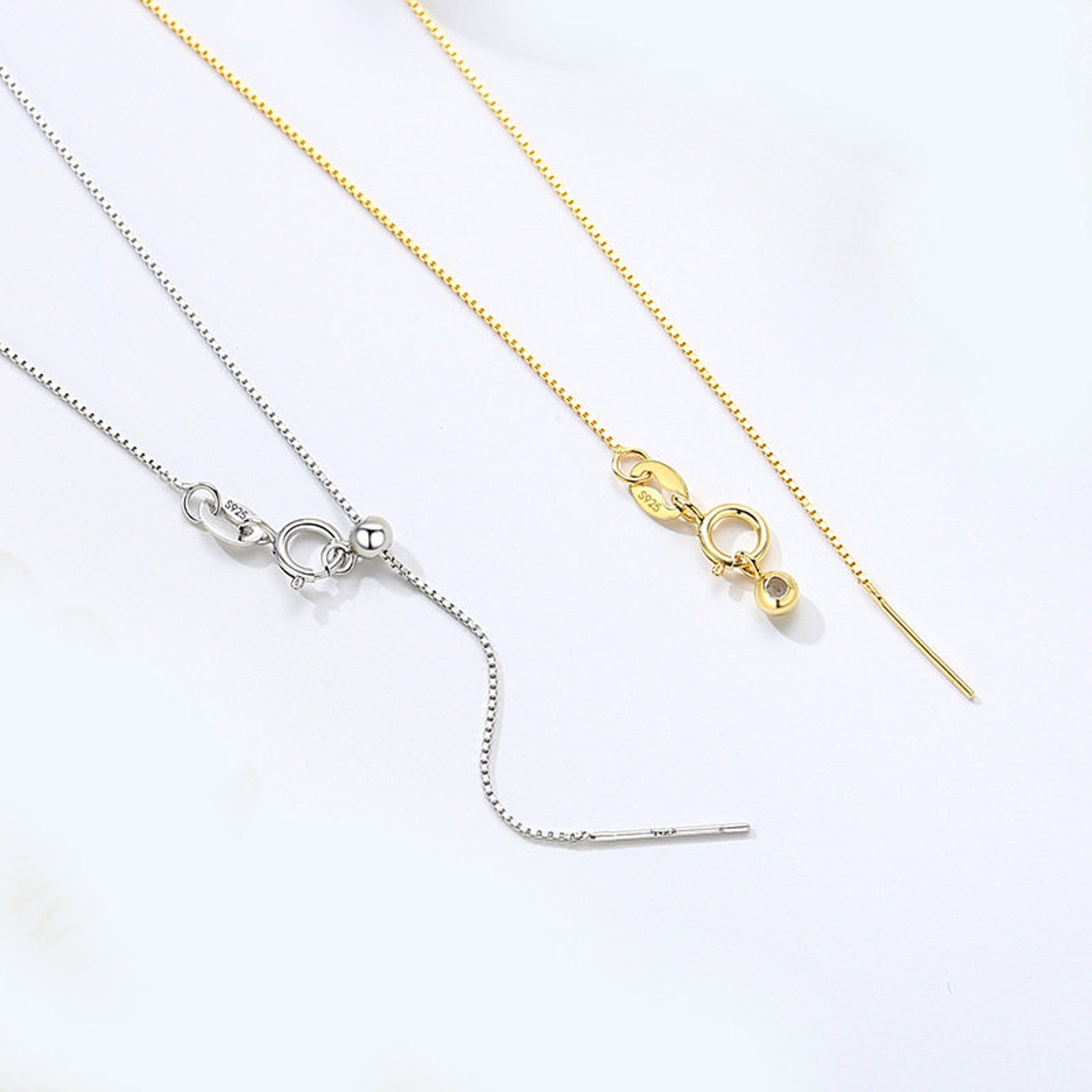 Side view of sterling silver chain necklace showcasing dual-tone silver and gold metallic finish