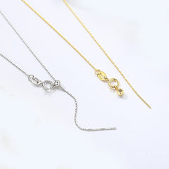 Side view of sterling silver chain necklace showcasing dual-tone silver and gold metallic finish