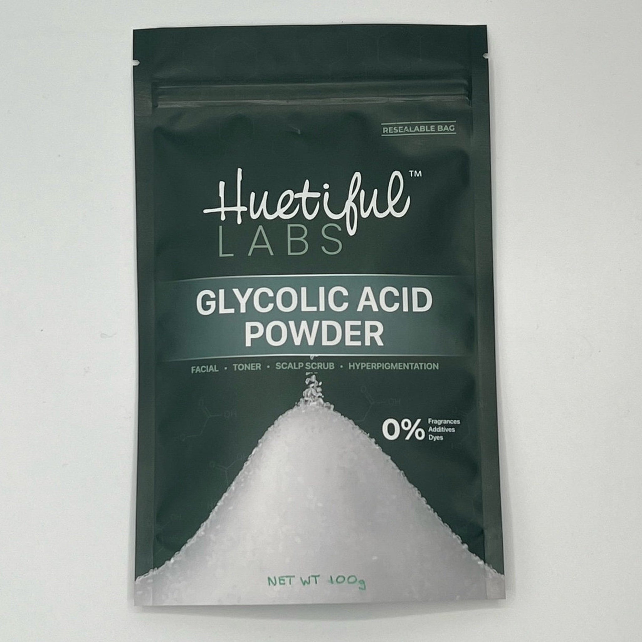 Glycolic acid powder in a dark green bag with white powder and Huetiful Labs text visible