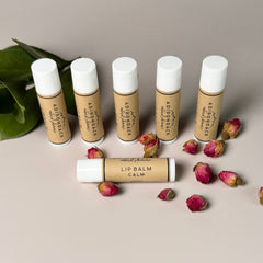Lip balm tubes with white caps and brown labels, Adirondack Natural Skincare brand, with dried roses