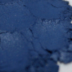 Side view of deep matte navy blue loose powder eye shadow in vegan celestial makeup, showcasing rich pigment texture