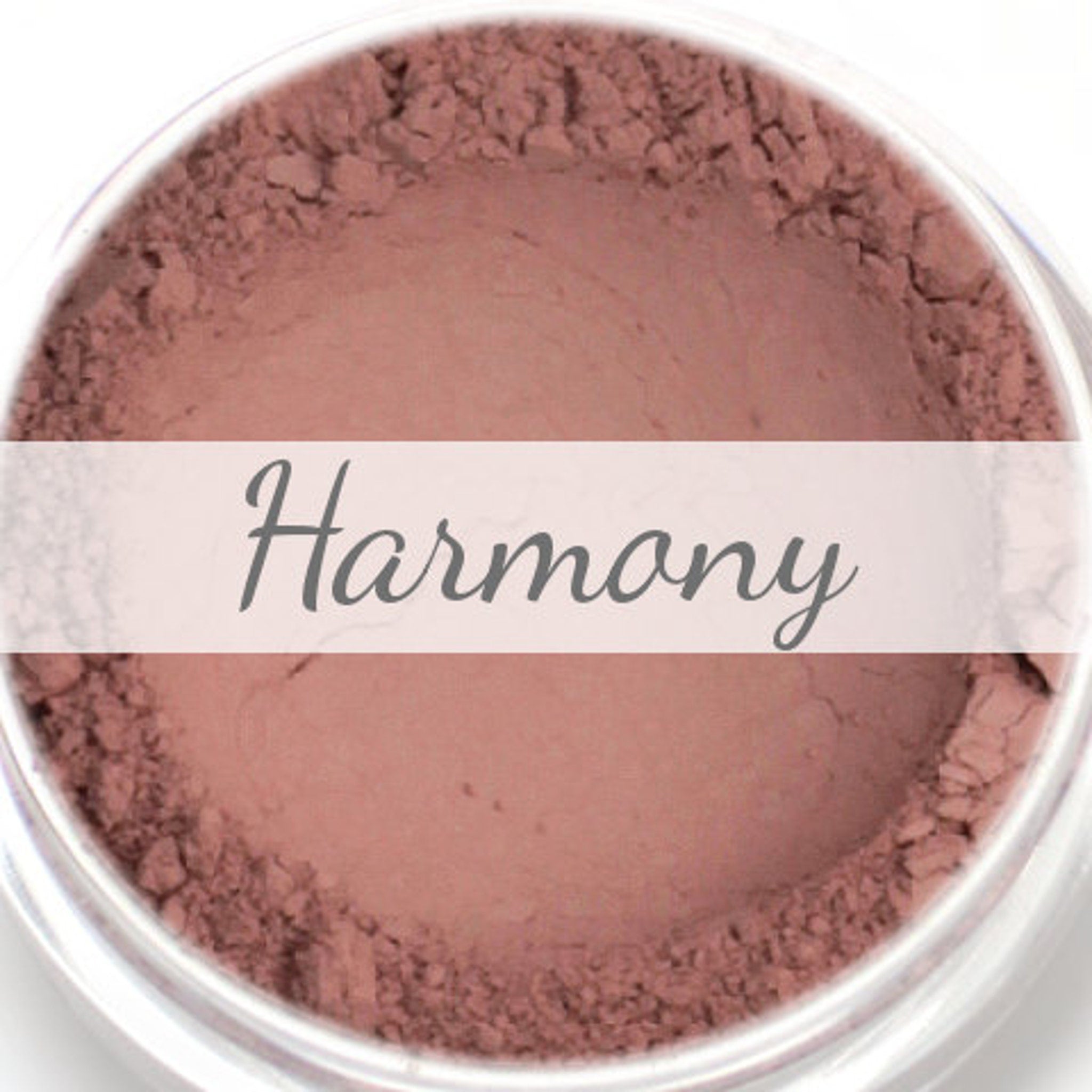 Eyeshadow sample, matte beige pink powder, "Harmony" text overlay, in a clear container