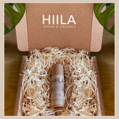 Lip balm tube in cardboard packaging with shredded paper, brand name HIILA visible