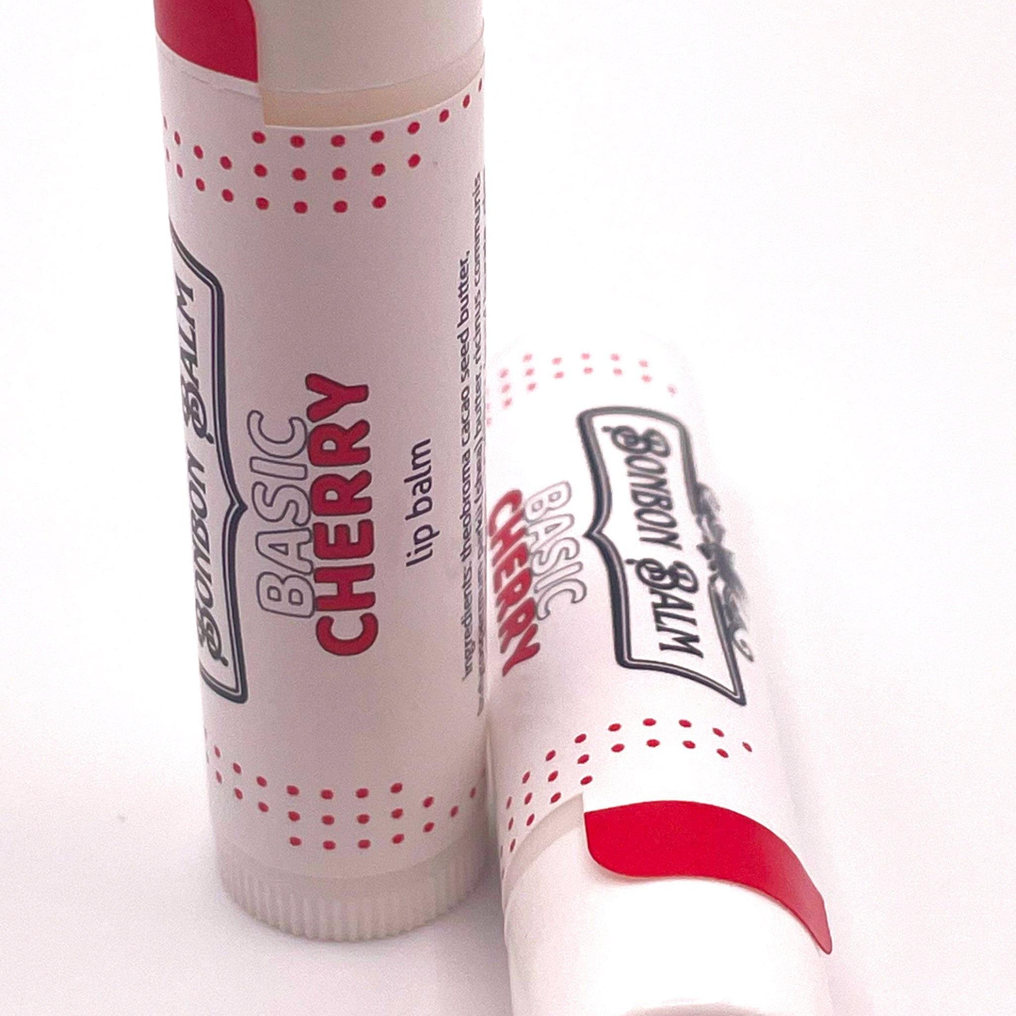 Lip balm tubes with red and white polka dot pattern, Bonbon Balm Basic Cherry label on white background