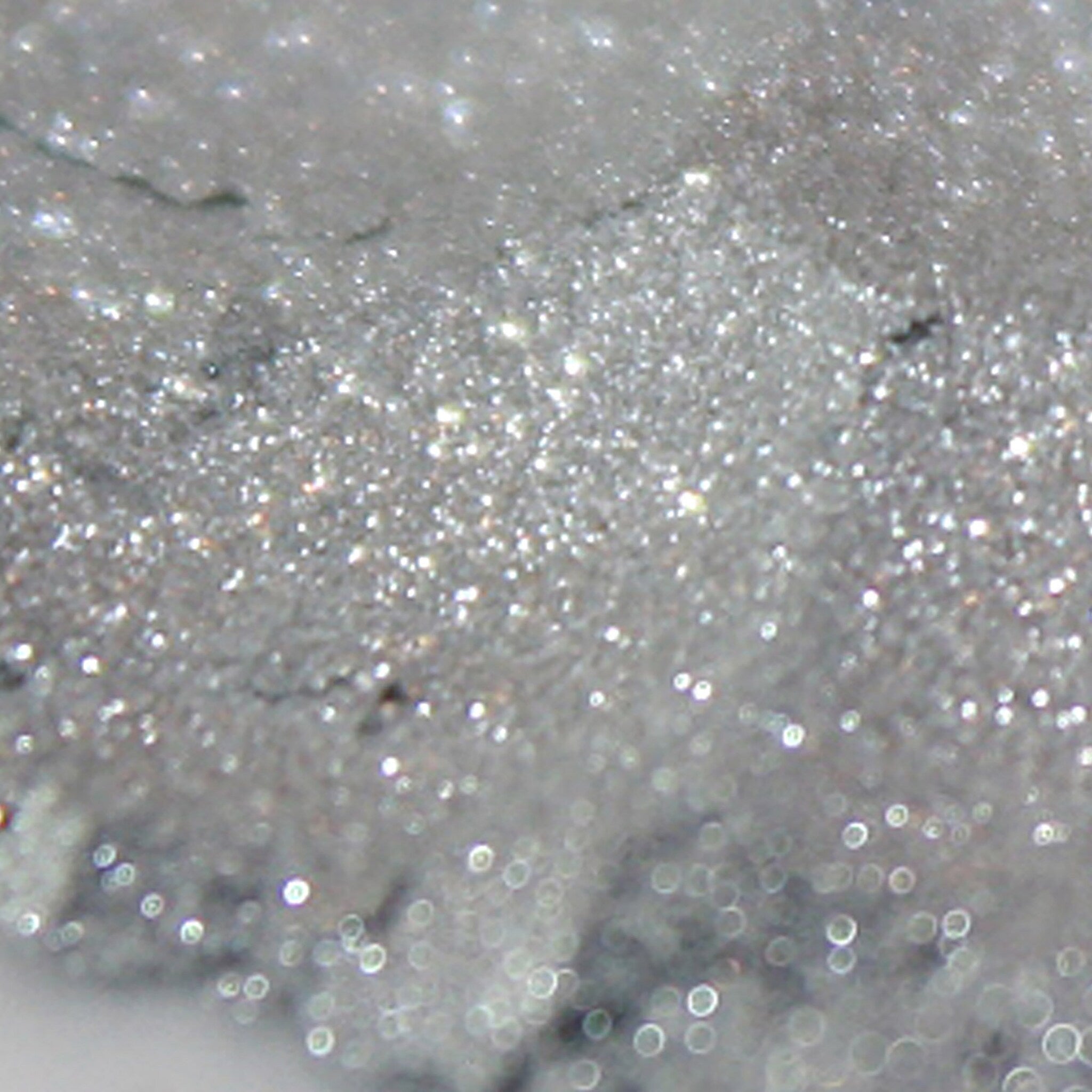 Silver glitter material with sparkling highlights and bokeh effect background