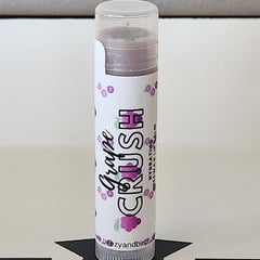 Lip balm tube with white label, purple text, and grape pattern, by BEEzy & Birch