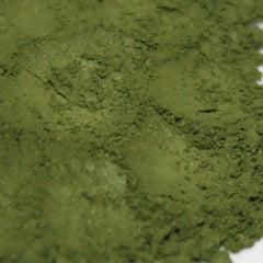 Green powder with textured surface and light color variations, close-up view