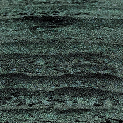 Hand applying deep emerald green shimmer eyeshadow with duochrome effect using a fluffy brush