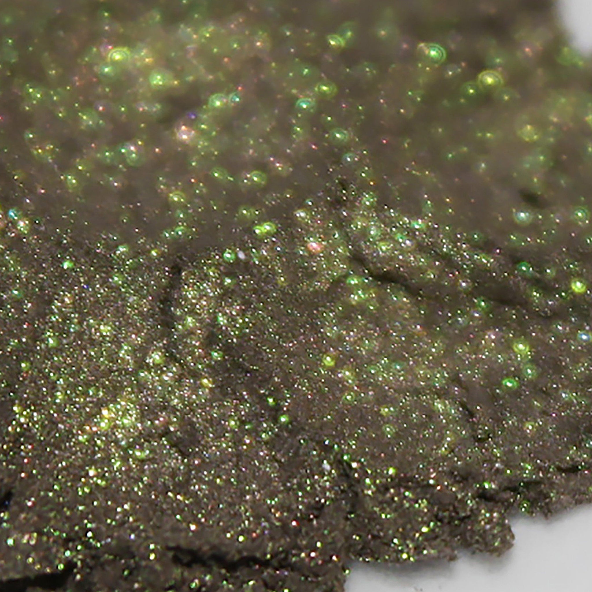Glittery green and brown material with sparkling highlights and rough texture