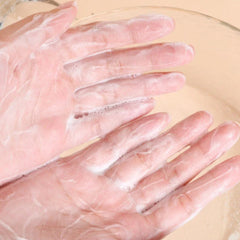 Hands with pink skin and white foam, washing in a clear bowl