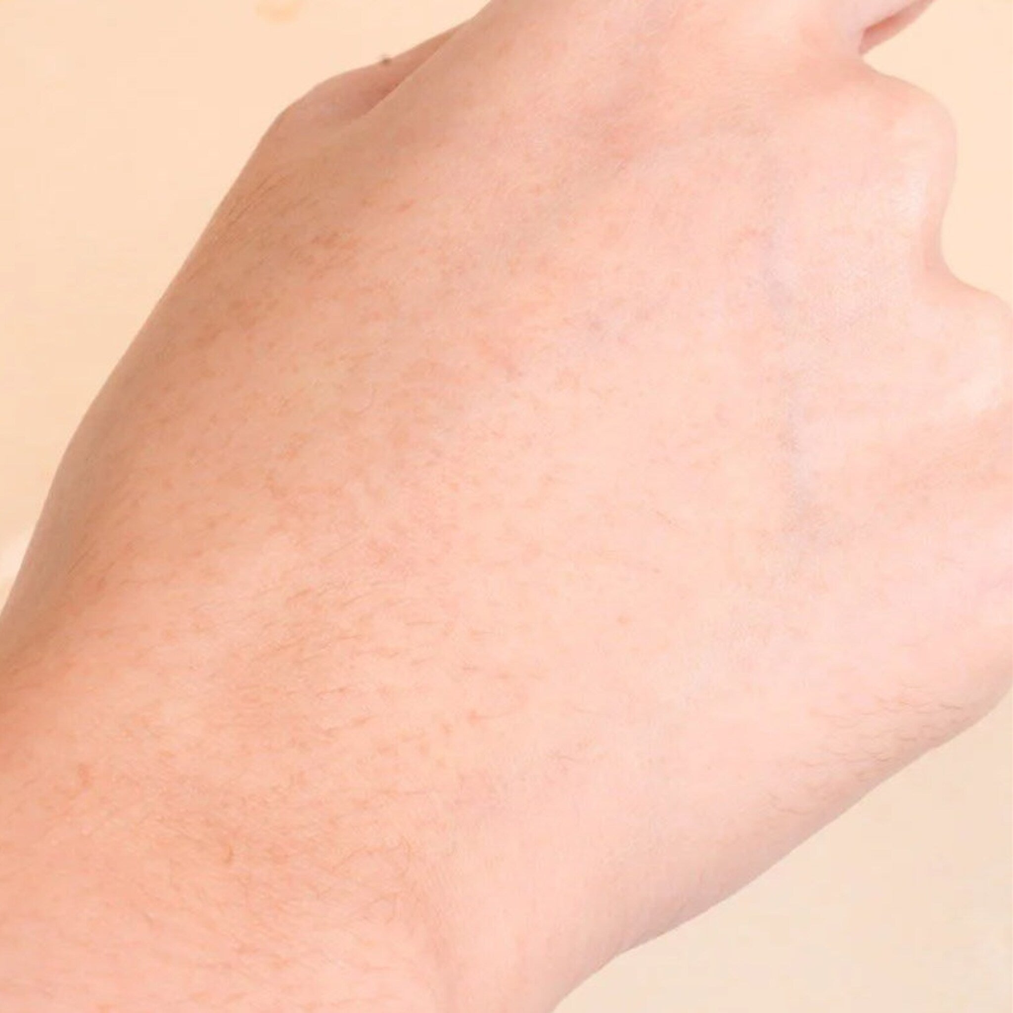 Human hand with peach skin tone, visible texture, and fine hairs on display