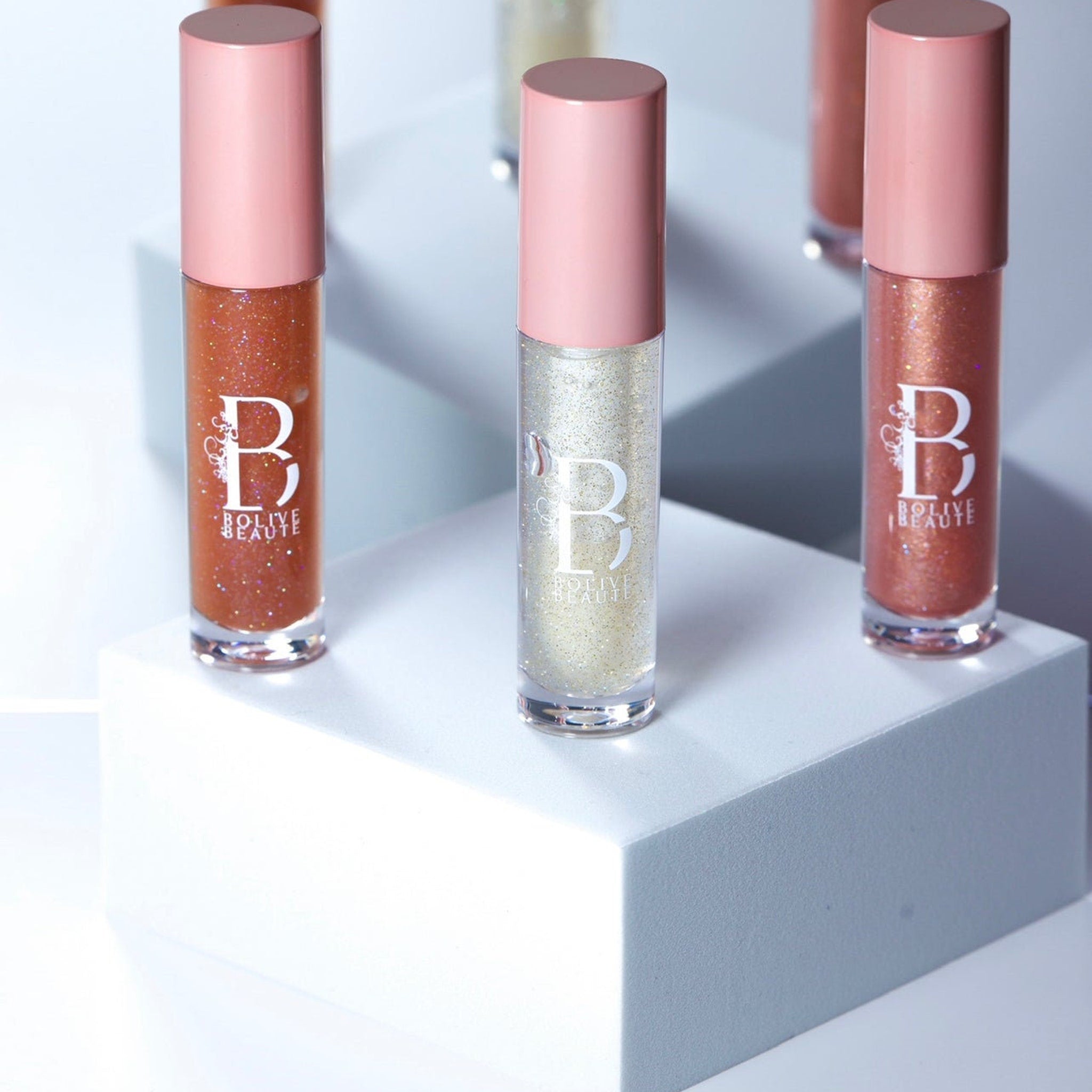 Lip gloss tubes with pink caps, clear glass, and Bolive Beaute branding