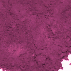 Side view of matte cyclamen loose powder eye shadow in deep pink and dark fuchsia, showcasing pigment texture