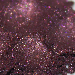 Side view of loose powder eye shadow in dark magenta pink and plum with shimmer finish, vegan goth romantic makeup