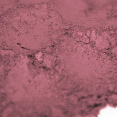Side view of warm pink matte loose powder eye shadow in minimalist round jar with soft beige blush undertones