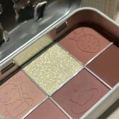 Side view of Kawaii Kpop eyeshadow palette showing pastel pink, lavender, and gold shimmer shades in rectangular pans