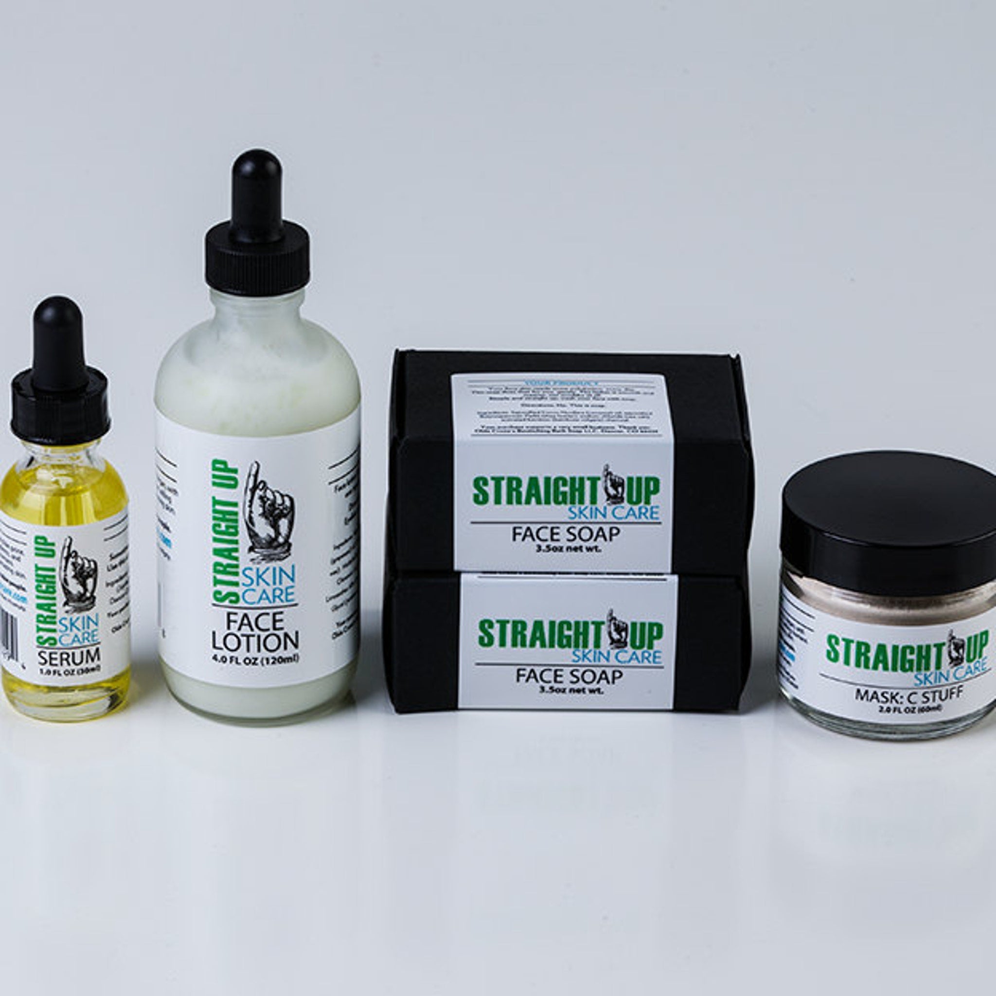 Skincare set with yellow serum bottle, white lotion bottle, black soap boxes, and jar with Straight Up Skin Care text