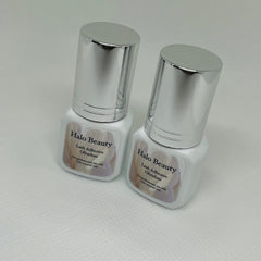 Lash adhesive bottles with silver caps, white label, Halo Beauty brand name visible