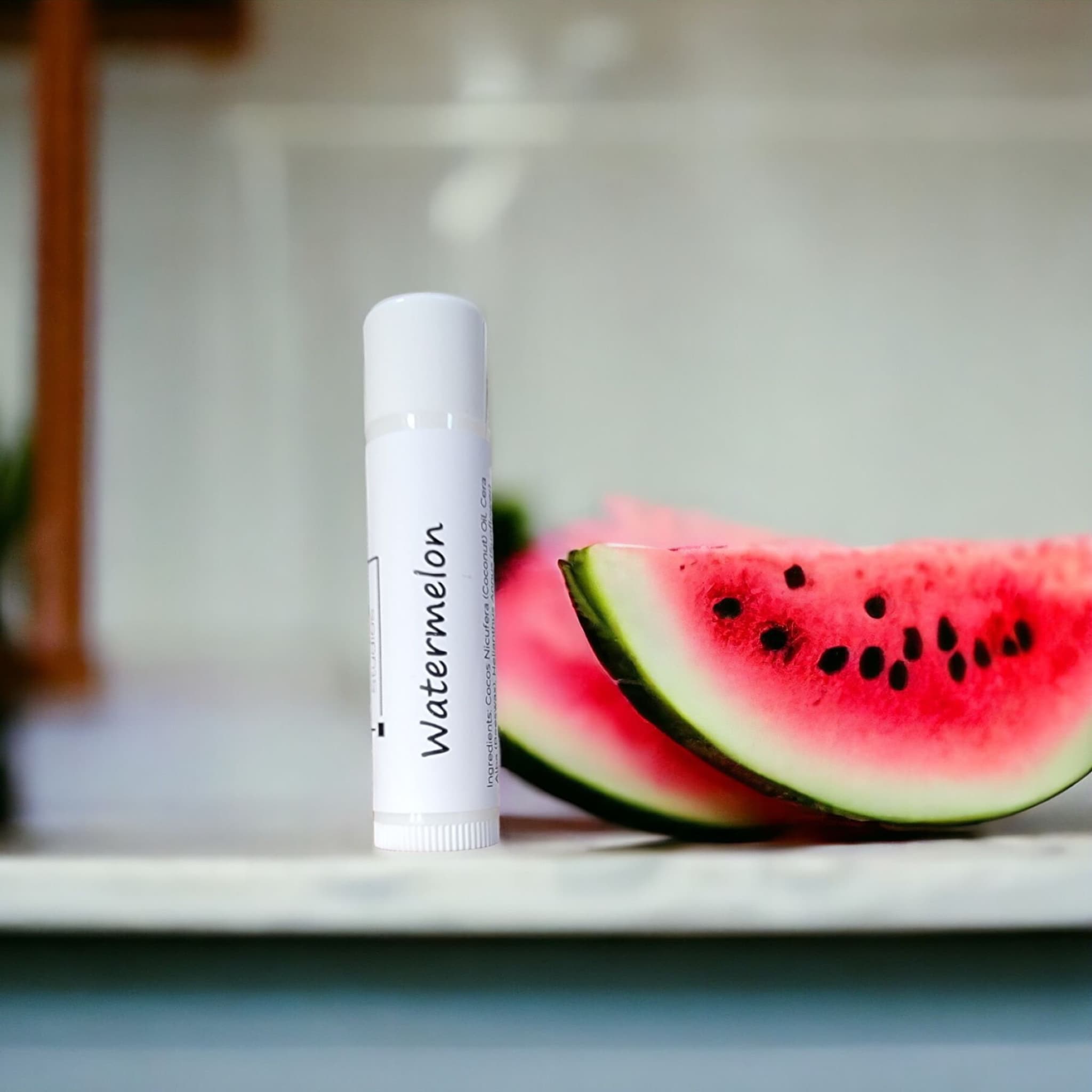 Lip balm tube with white label and watermelon slices, KraftyChickStudios branding visible