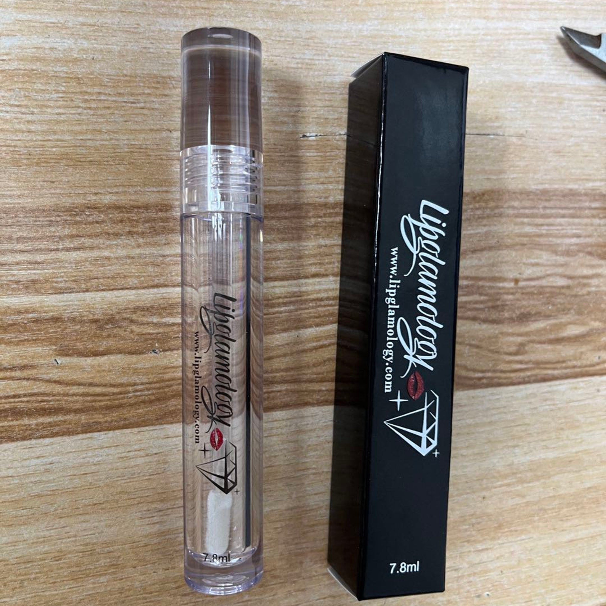 Lip gloss tube clear plastic with black box, Lipglamology brand text visible