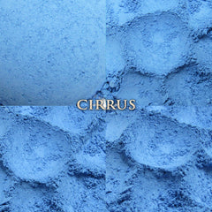 Side view of loose powder blue vegan eyeshadow in a clear jar with black screw-top lid, showcasing fine matte texture.